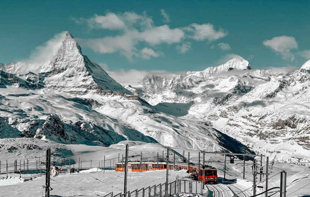 snow covered mountain Matterhotn under blue sky during daytime as symbol of swiss tourism