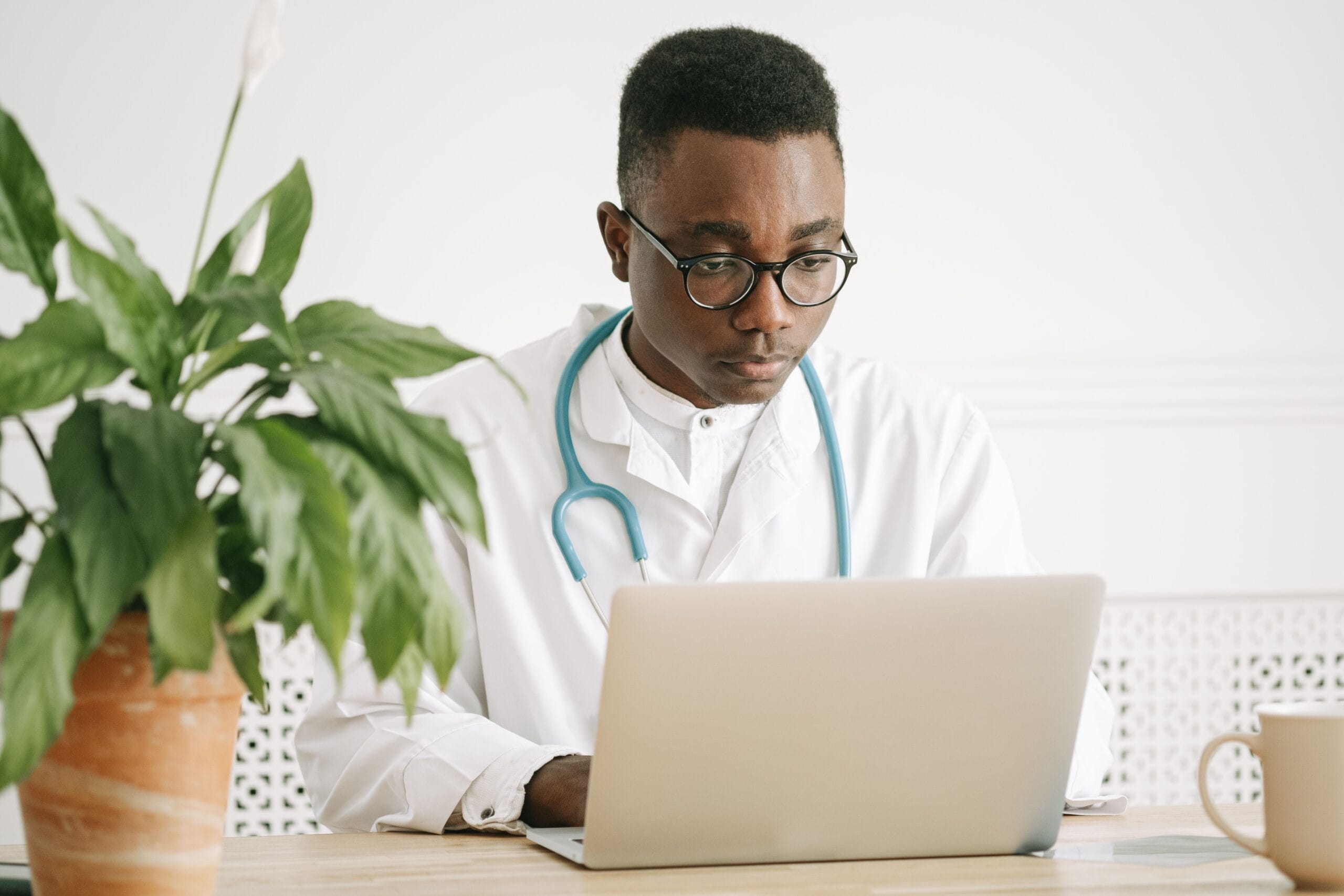 Arzt arbeitet am Laptop in einem modernen Praxisbüro – Digitalisierung im Schweizer Gesundheitswesen