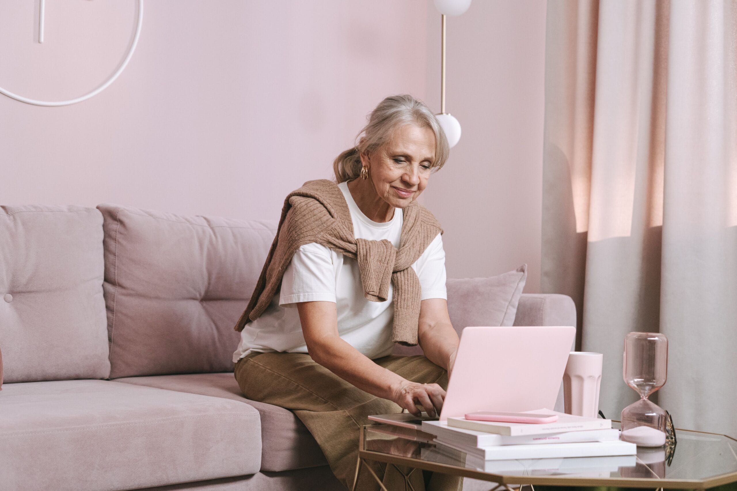 Ältere Frau arbeitet konzentriert und selbstständig am Laptop zu Hause