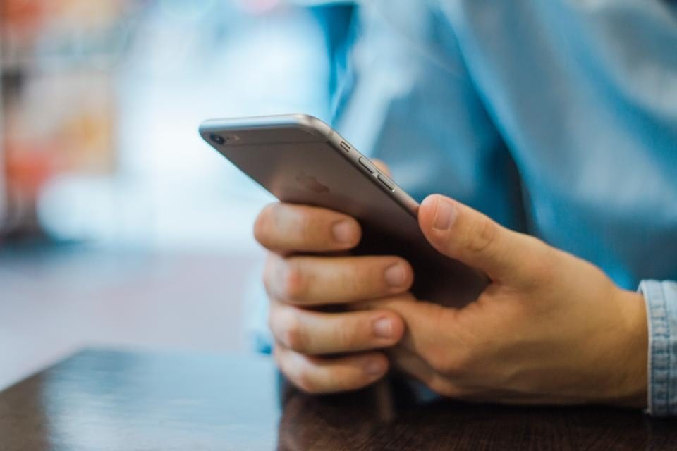 Person bedient eine Website auf dem Smartphone mit einer Hand